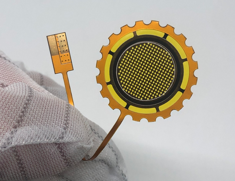 Hand holding a flexible PCB (flex circuit) used in wearable electronics and compact electronic devices